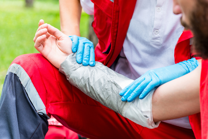 Medical worker treating burns on man's hand. First aid training