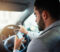 Cropped shot of a man using his phone while driving