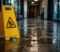 slip-and-fall-image Yellow wet-floor caution sign in a hallway warning of slippery surface ahead on a glossy tiled floor